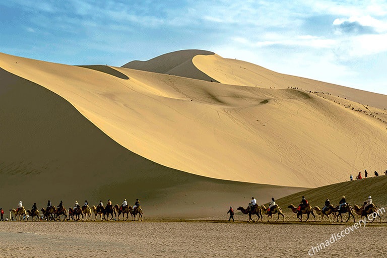 Riding camel while trekking in Badain Jaran Desert