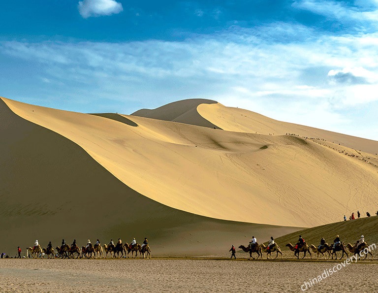 Riding camel while trekking in Badain Jaran Desert