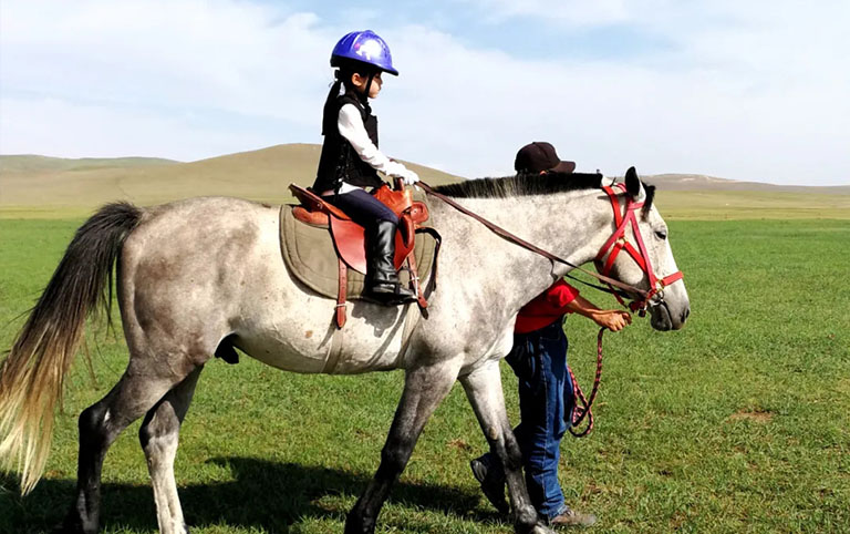A Kid is Triying Horse Riding in The Mongol Khan City