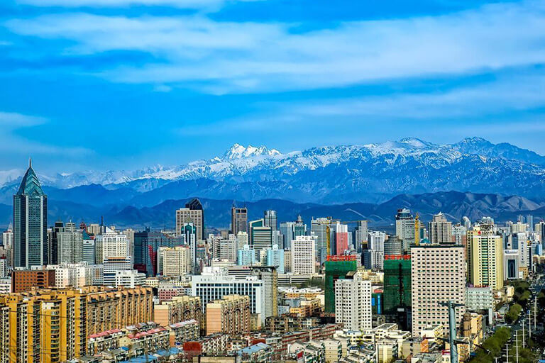 Modern Urumqi city with Tianshan Mountains as background